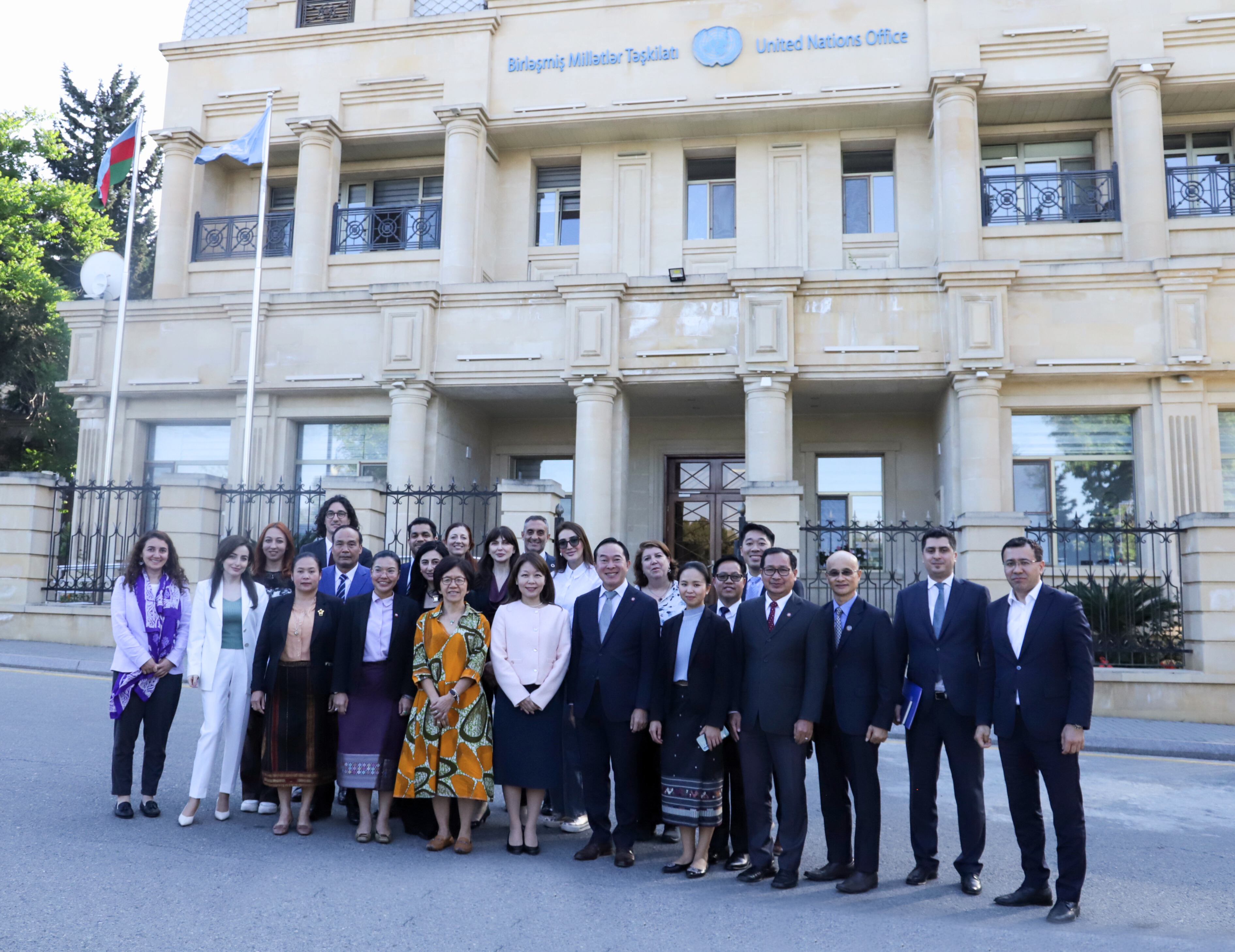 A group of people looking at the camera with the UN office in the background 