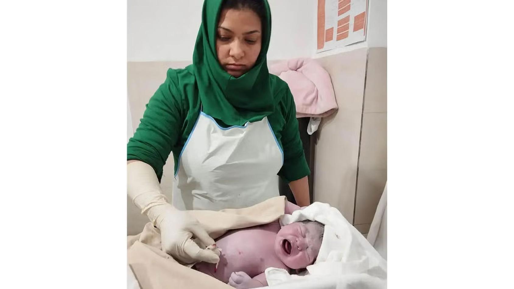 A woman is tending to a newborn baby 