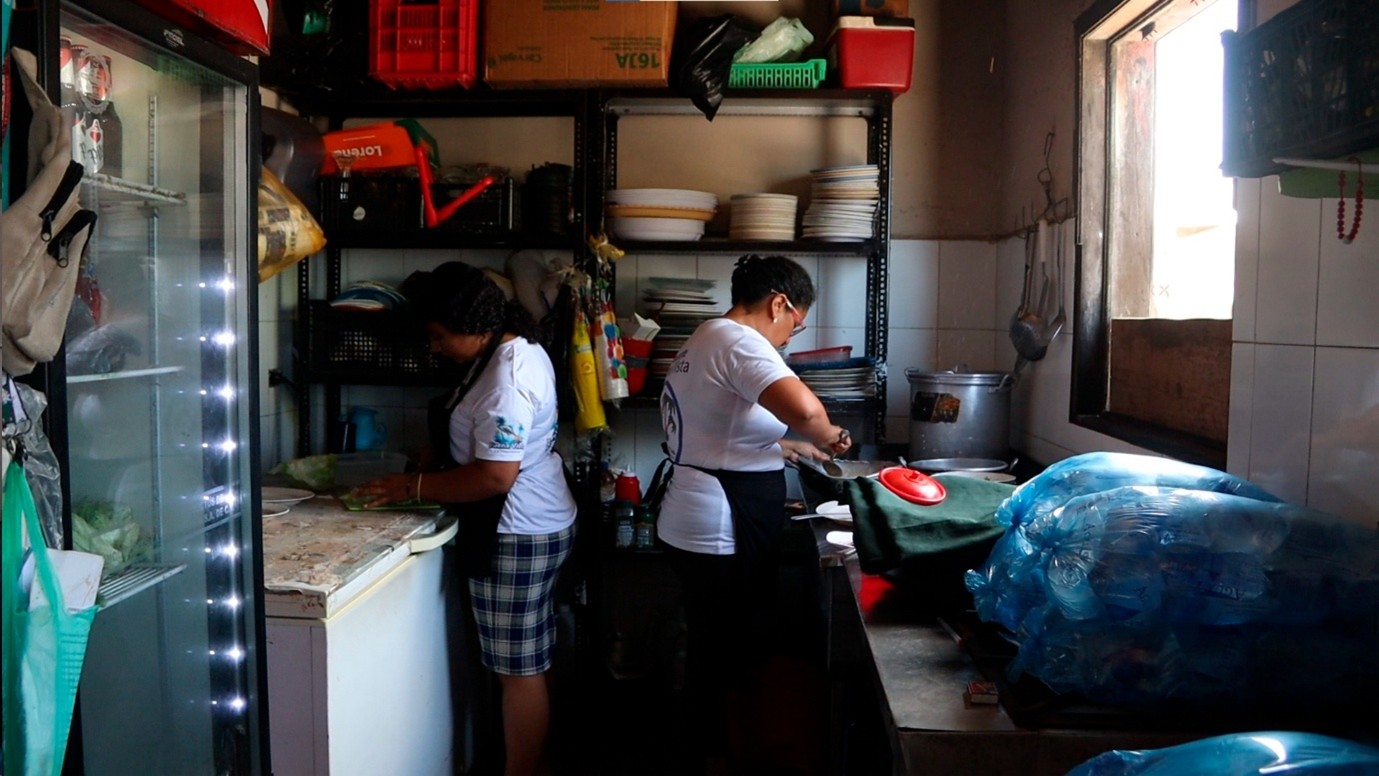 Two women in El Salvador prepare a meal.