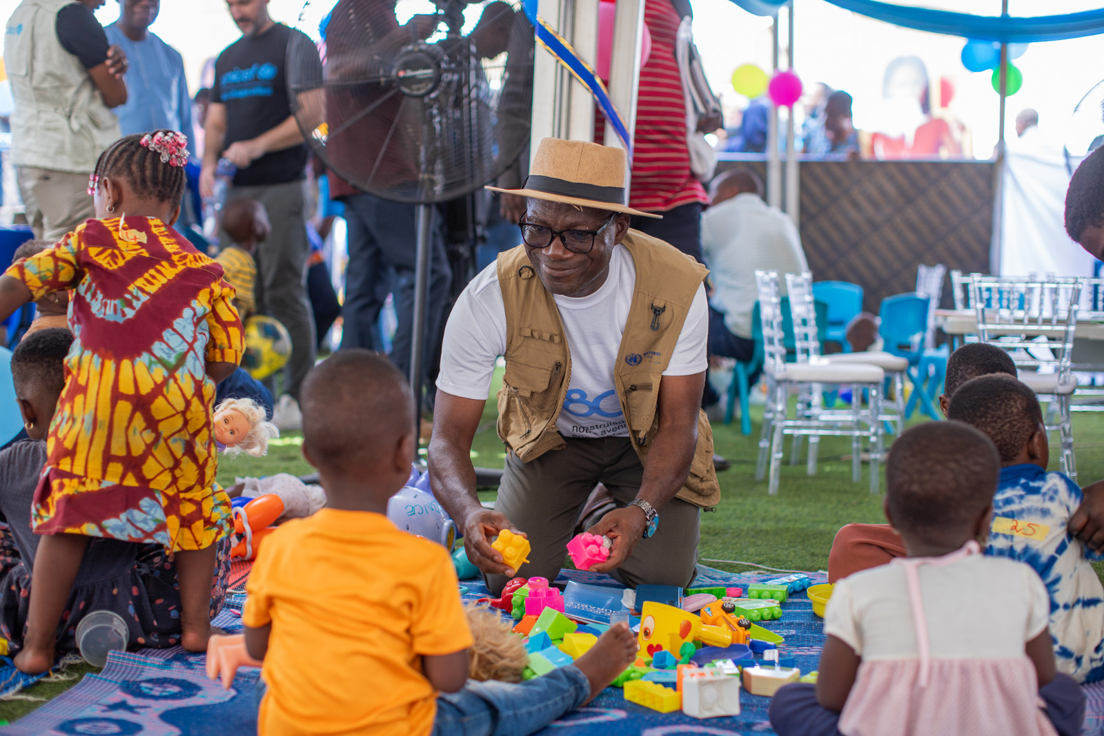 A man in Togo plays with children.