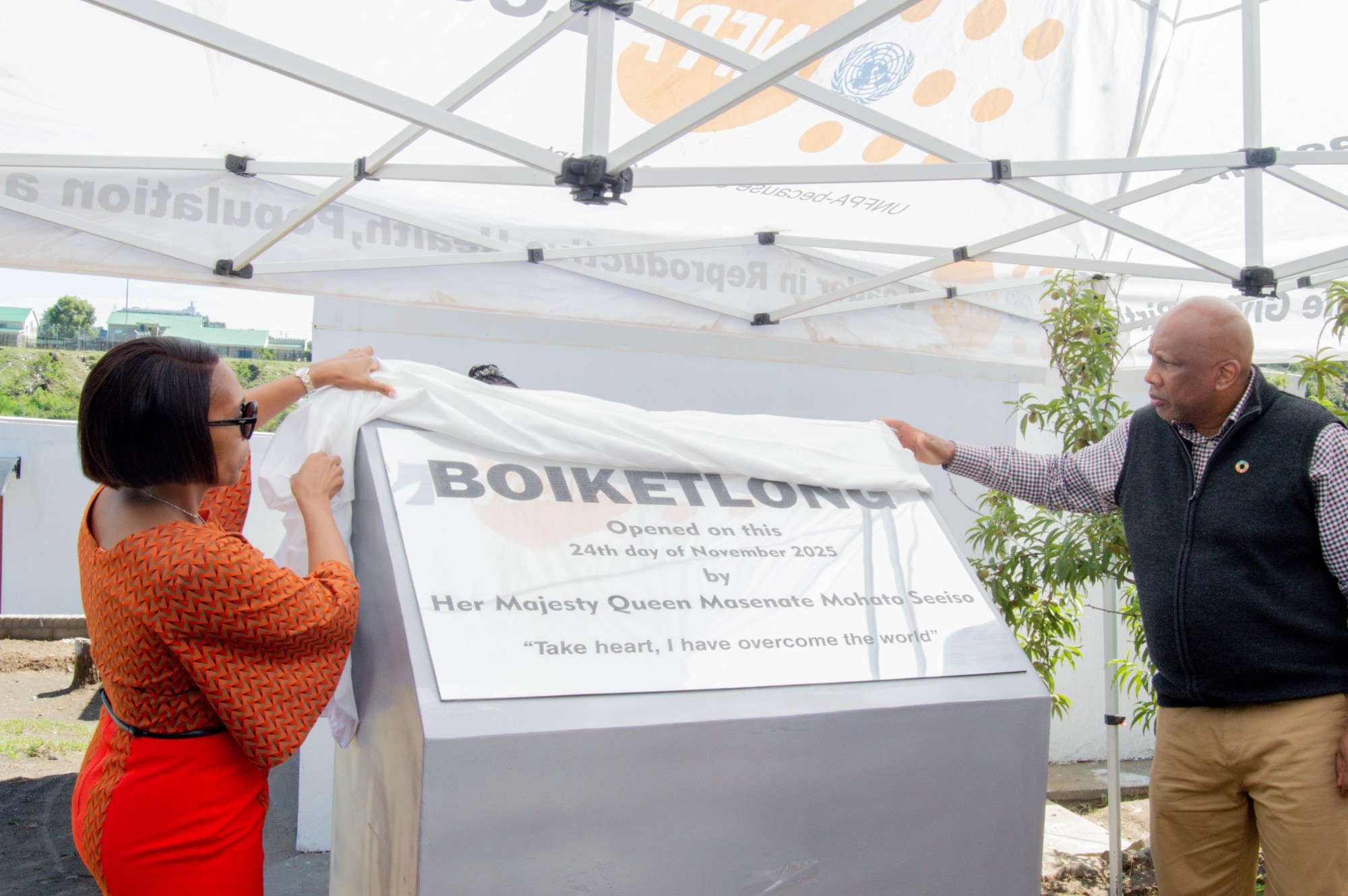 The King and Queen of Lesotho unveil a sign commemorating a new women's shelter.