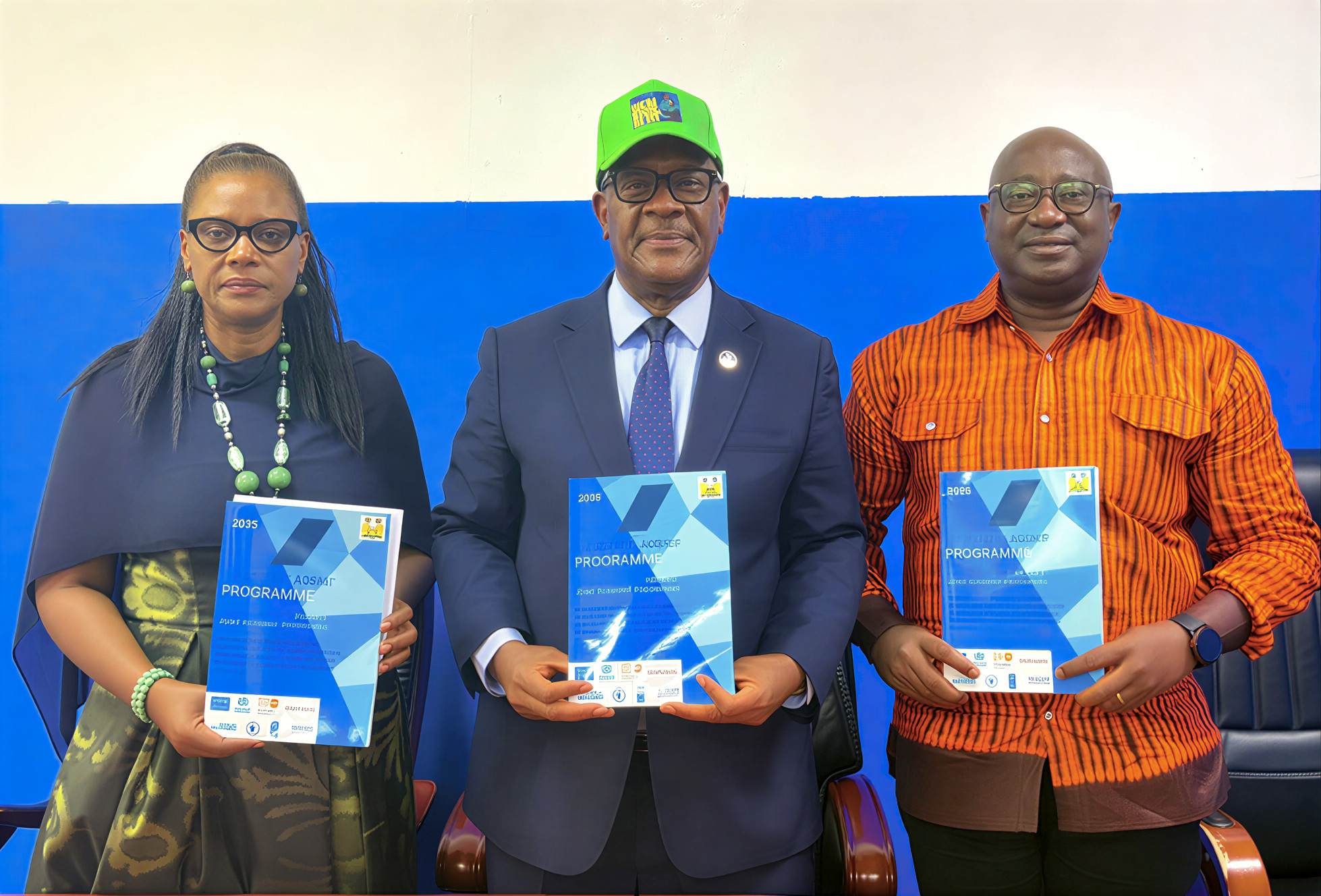Three high-level officials pose for a photo holding a new health policy in Sierra Leone.