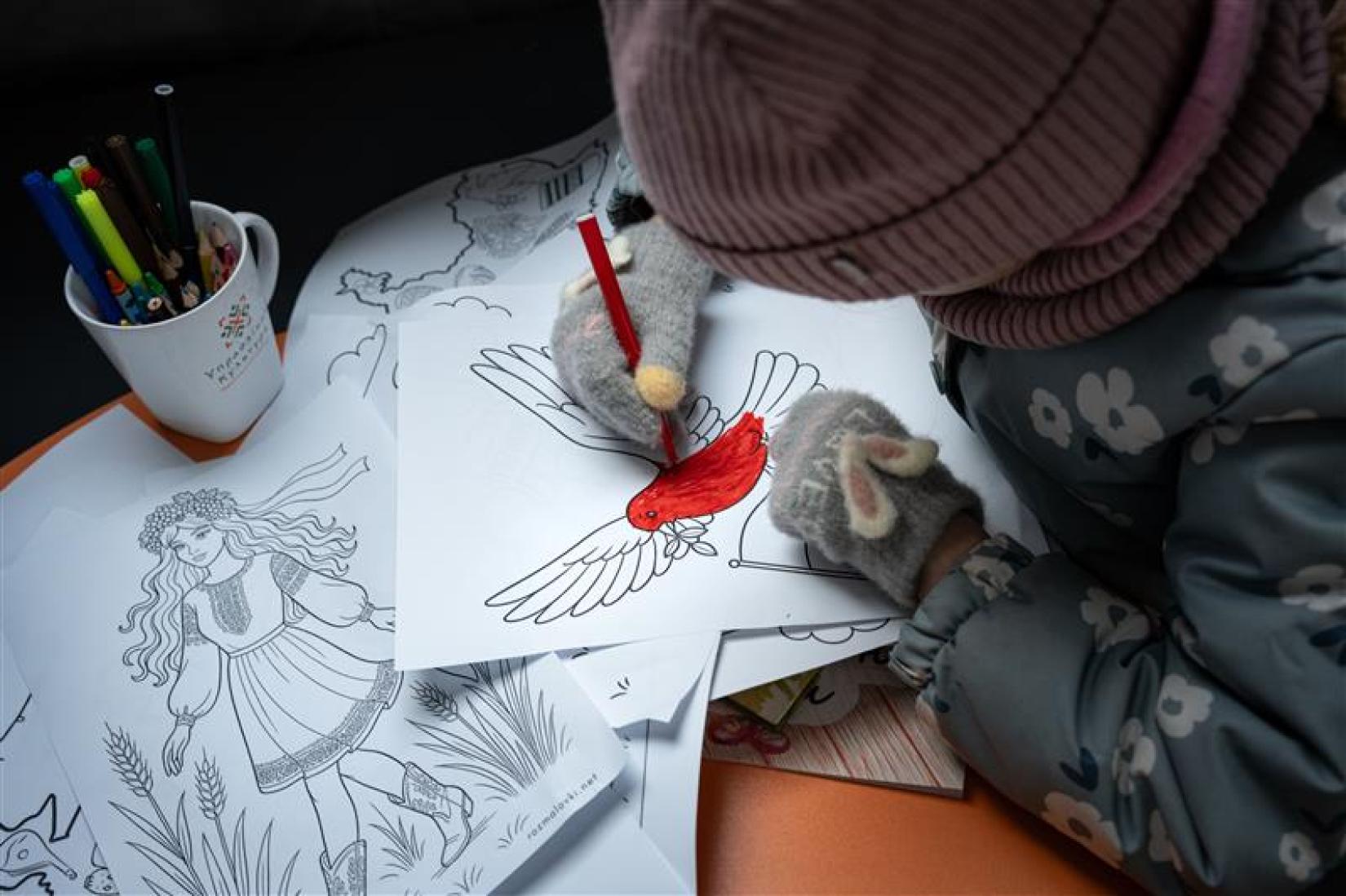 A girl in Ukraine paints an image of a dove.