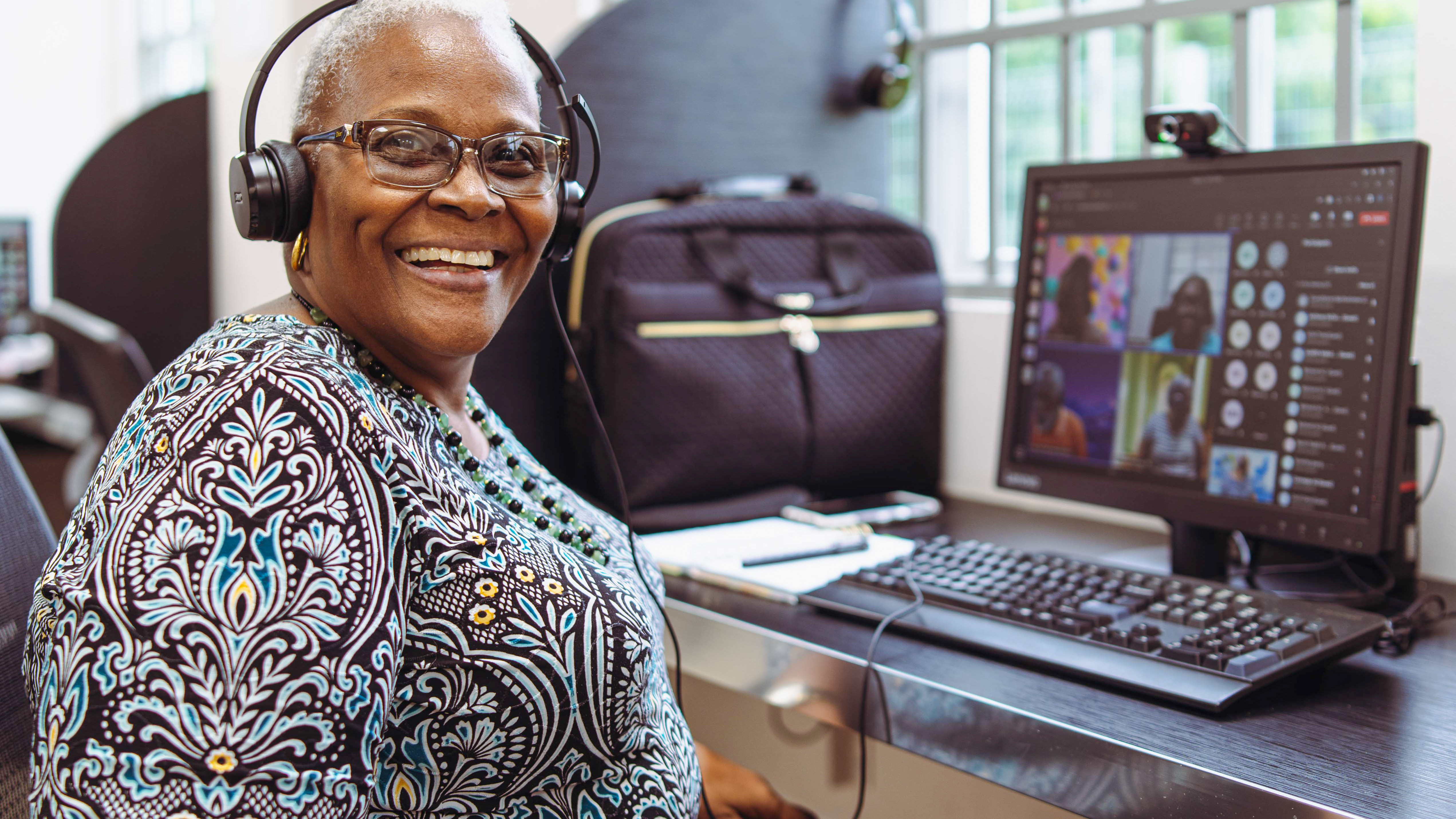 A woman in Trinidad speaks to colleagues through an online web platform.