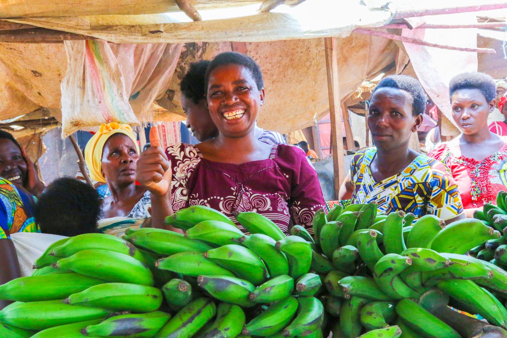 Women stands at fruit market with bananas 