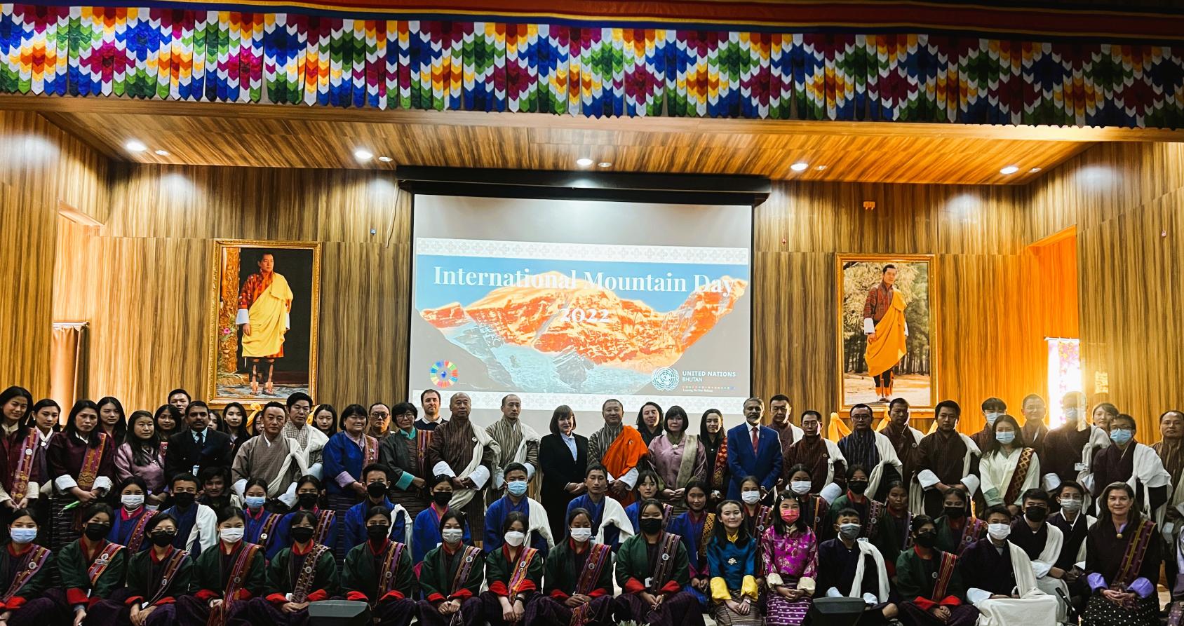 A large group of people near a large screen with the words Mountain Day.