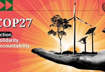 An image of a hand holding a tree and solar power windmills next to the words COP 27.