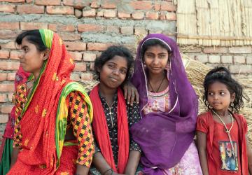 Group of children stand against a brick wall 