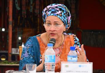 women in colourful headscarf speaks into microphone 
