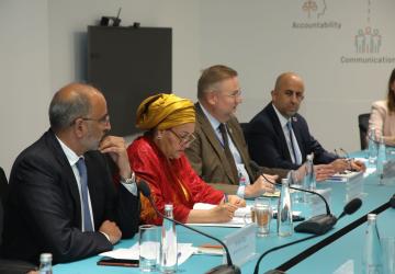 group of three men and one woman sit at panel discussion 