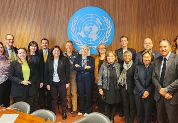 group of people standing in front of UN sign 
