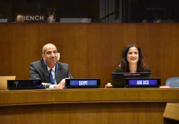 man and woman in suits sit next to each other in meeting room 