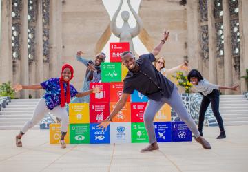 Group of children pose next to SDG blocks 