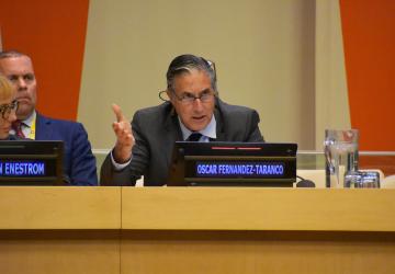man in dark suit speaking at panel 