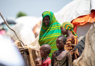 woman in green shall holds a child 