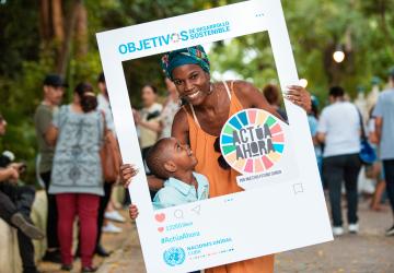 mother and son pose with SDG cut out poster 