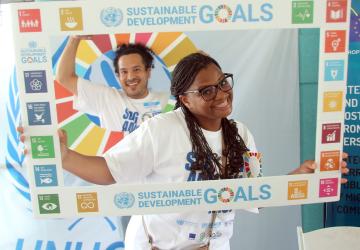 young boy and girl pose behind SDG cut out poster