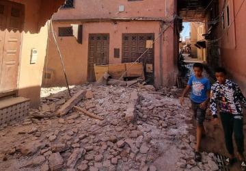 children walk among the rubble of buildings affected by the earthquake in Morocco