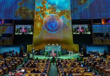 view of UN General Assembly lit up with light projection of the world map 