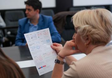 A woman is reading an infographic during a workshop. She is looking away from the camera