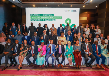 A group of people seated at an event with the words Africa Cooperatio Forum in the background