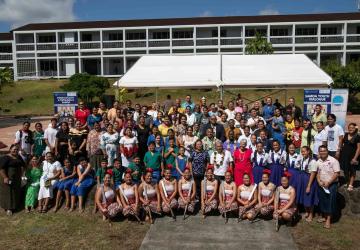 A group of people in an outdoor setting with young people in traditional dress and the UN Secretary-General. 