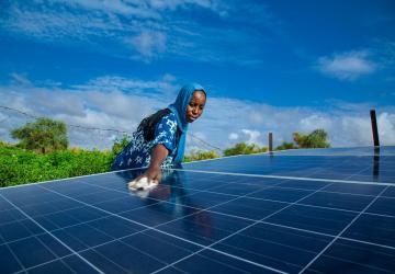 A woman is cleaning a solar panel outdoors