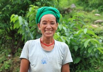 A woman looking at the camera and smiling in an outdoor setting