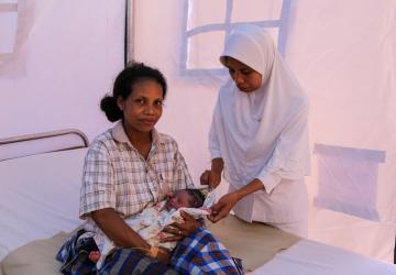 A nurse attending to a newborn and mother