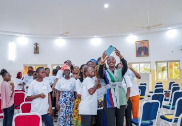 A high-level UN official takes a photo with female high school students in Togo.