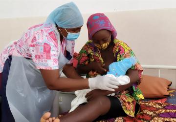 A nurse in Sierra Leone tends to a mother's baby.