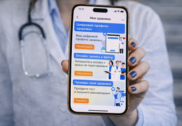 A doctor holds a phone displaying an e-health app.