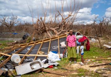 A woman and her son in Jamaica stand amidst the debris caused by a hurricane.