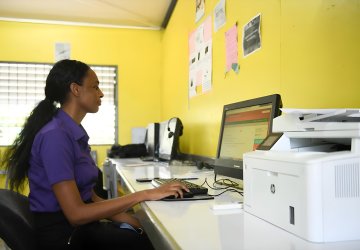 A woman in Jamaica uses a computer.