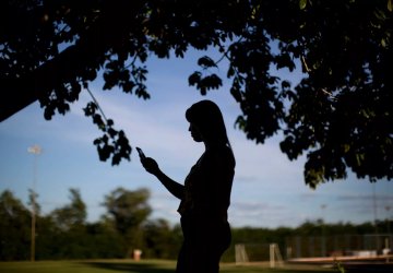 A woman looks at her phone.