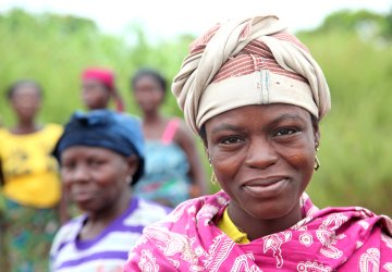 A woman in Benin stands in front of other women.