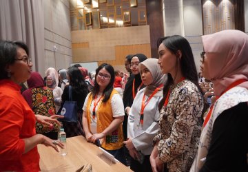 A woman leader in Indonesia talks to young women at an event.