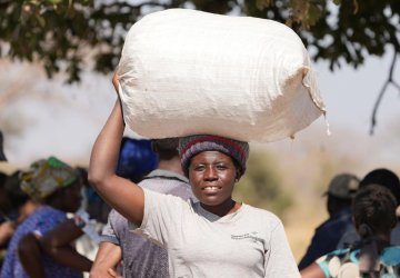 A woman in Namibia carries a bag on her head.
