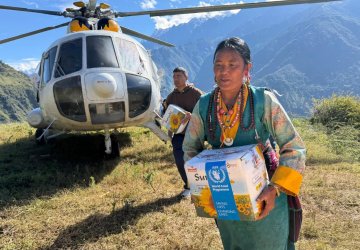 An aid workers delivers supplies after floods in Nepal.