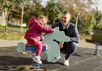 A father and his daughter at a playground in Montenegro.