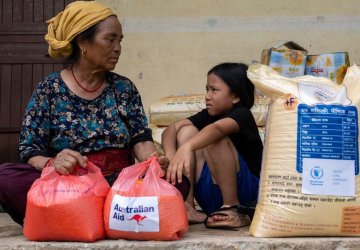 A woman and child in Nepal receive aid following floods.