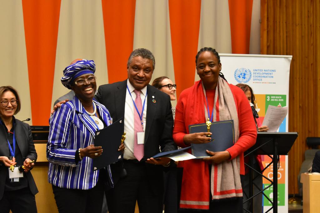 two women and a man stand next to each other smiling at the camera 