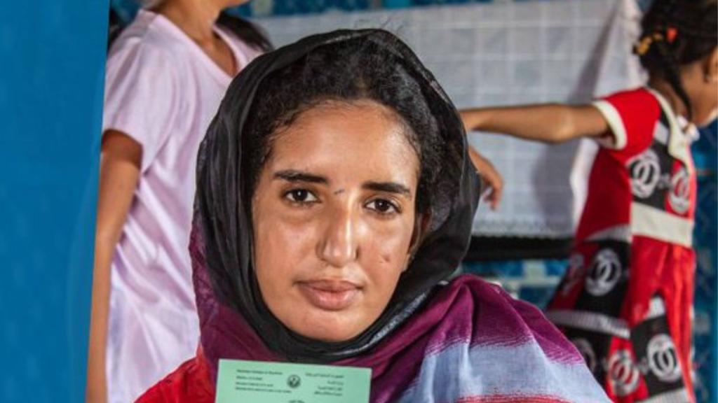 A woman holding a voter registration card
