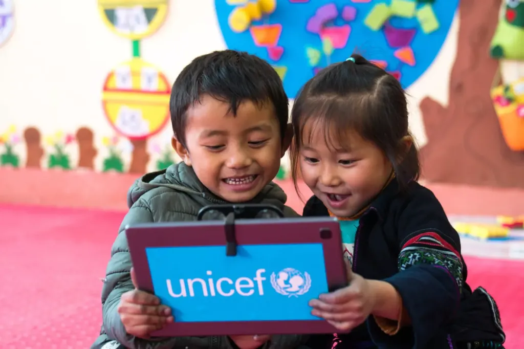 Two young children looking at a tablet