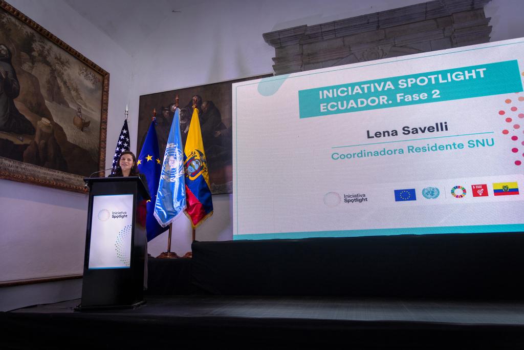 UN Resident Coordinator in Ecuador, Lena Savelli, speaks behind a lectern.