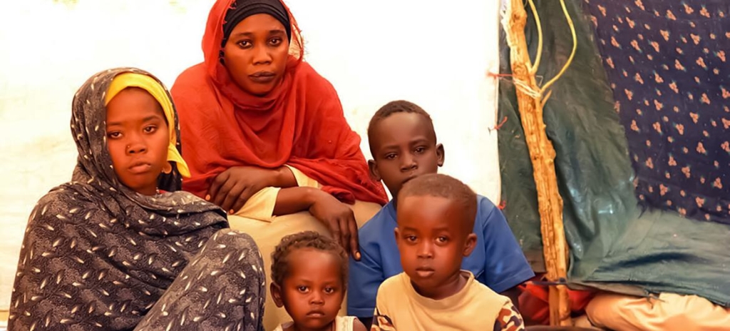 A group of children in a camp looking at the camera 