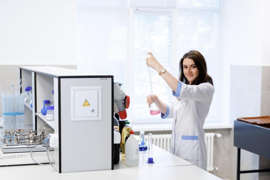 A female doctor is wearing a white coat in a lap and using research equipment 