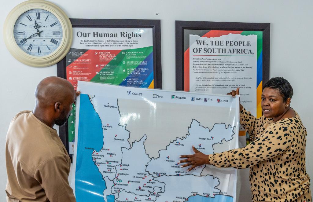 Members of a civil society organization in South Africa show a map of support services.