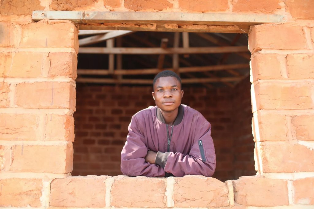 A child in a house under construction in the DRC.