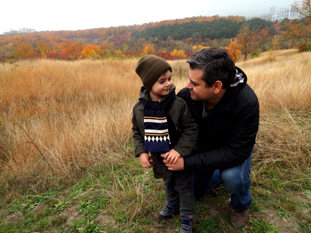 A man embraces his son in a field in Moldova.